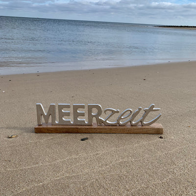 Schriftzug Meerzeit auf Holzfuß